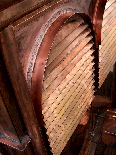 Des casquettes en cuivre naturel, soudées sur le placage, protègent de toute infiltration d’eau derrière les abat-son