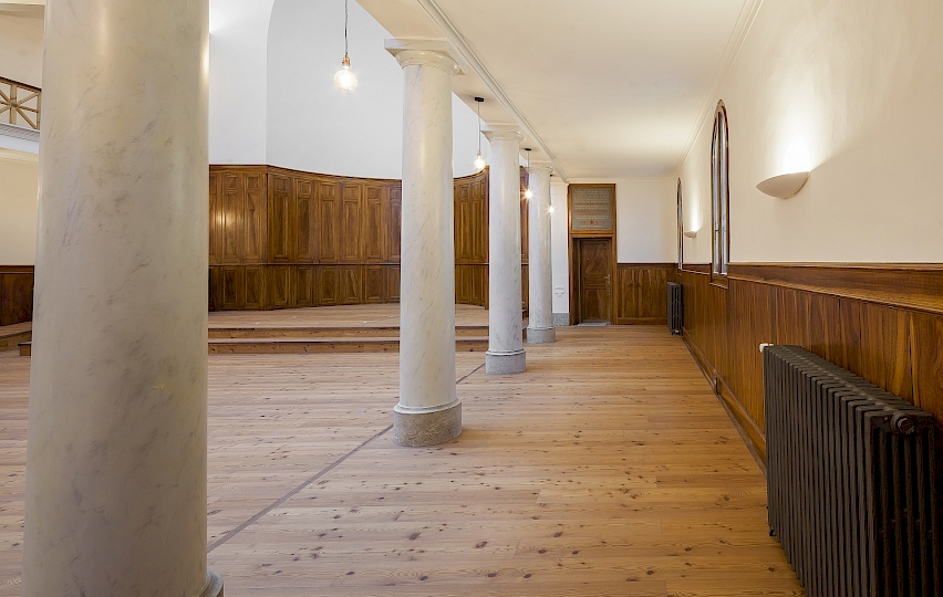 Vue du côté latéral Est de la nef. On aperçoit la porte d’accès à l’arrière cour. Cet espace de circulation est aussi utilisé comme zone de prière. Photo après travaux.