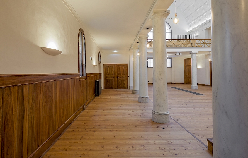 Vue du côté latéral est de la nef central après travaux. On aperçoit la porte d’accès depuis l’espace de distribution. On remarque que les fenêtres de la façade Est on déjà été équipées de doubles fenêtres intérieures avec du verre isolant.