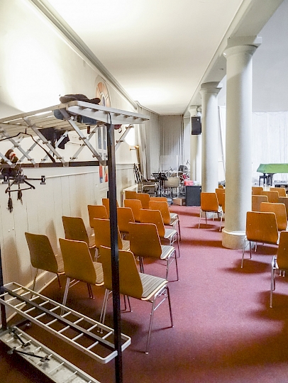 Vue du côté latéral ouest de la nef central avant travaux. On aperçoit au fond, l’espace utilisé pour le rangement et l’utilisation des instruments de musique. Aujourd’hui, cet espace est occupé par une rampe d’accès a la scène.