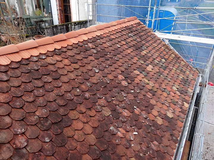 Panachage des tuiles récupérées. Remplacement des tuiles faîtière et des doublis.