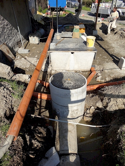 Canalisation des deux caniveaux à l'air libre de la fontaine et du mur ainsi que des deux descentes d'eau pluviales du couvert.