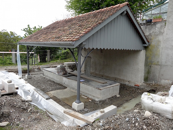 Vue d'ensemble, pose d'un emmarchement en calcaire d'Hauteville finement bouchardé et confection des caniveaux en pavé en grès 10x10cm.