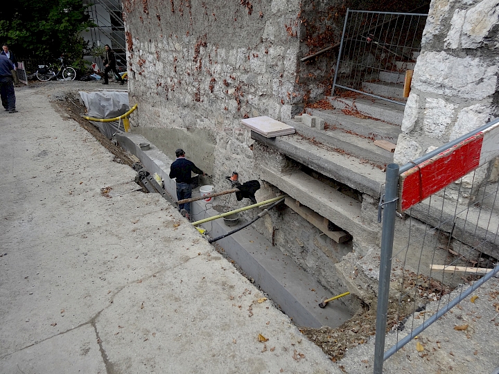 Façade sud, côté route. Application d'un enduit bouche pores sur la face contre terre.