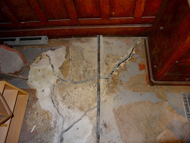 Mise en place des tirants au niveau de la nef, ici au droit du mur de refend. Les deux parties disloquées de la dalle à nervure visible sur cette photo seront retirées et refaites.