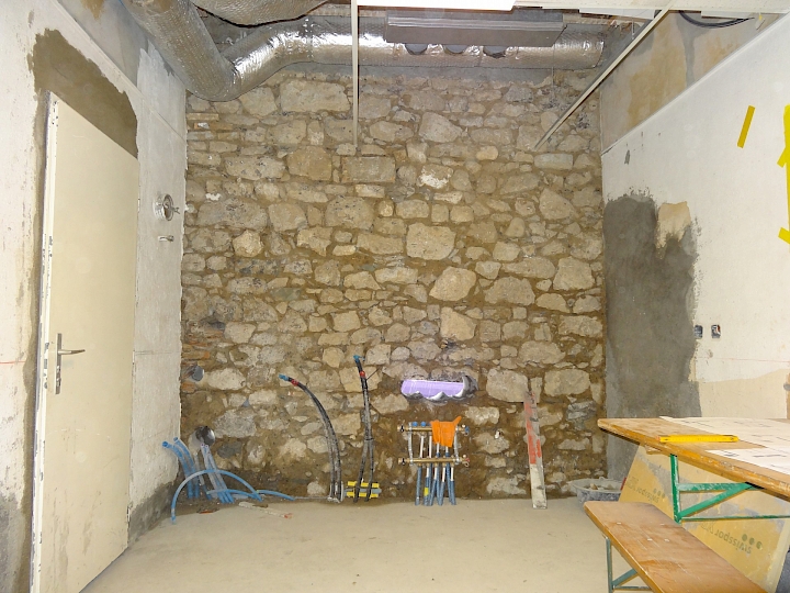 Piquage de l'enduit intérieur et assainissement du mur local cuisine, façade sud.