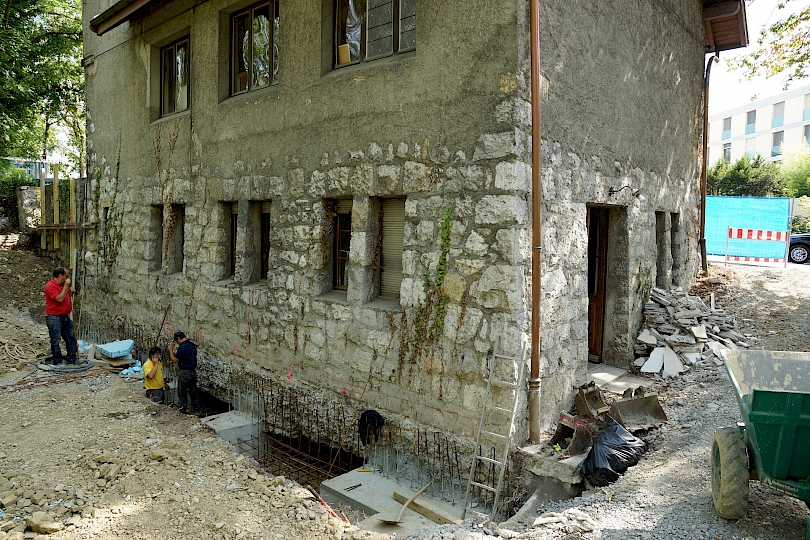 Vue générale des travaux de reprise en sous-œuvre, façade nord, côté forêt. 1ère étape; bétonnage des semelles de fondations.