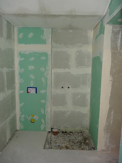 Intégration de doublages hydrophobes et isolants dans l'ancien local technique transformé en local de douche.